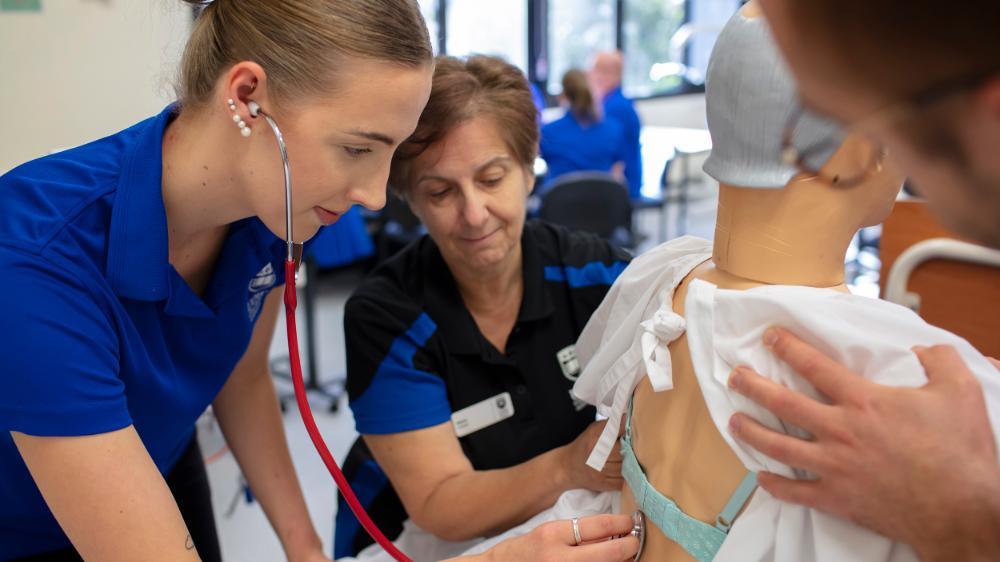 Nursing students working in simulation lab with patient